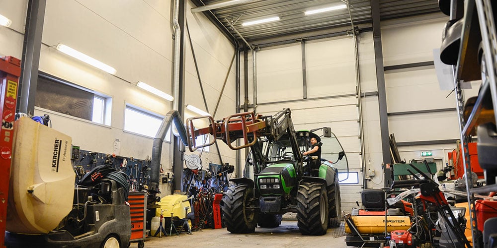 Jenka maskin-verksted-med-traktor-og-mann-i-arbeid_1000x500.jpg